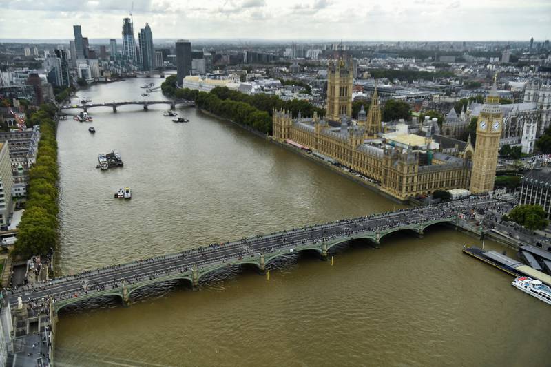 People queue on a bridge over the river Thames to pay their respects to Queen Elizabeth in London. Reuters