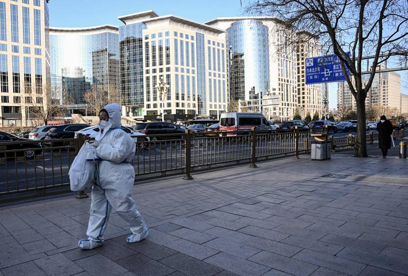 A woman wearing personal protective equipment (PPE) amid a sharp rise in Covid-19 cases in Beijing. AFP