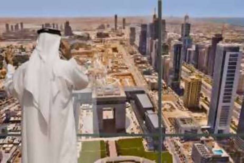Businessman stands at his office window while talking on his mobile phone, with his view of The Gate development, Dubai?s International Stock Exchange,the central business area under construction and tall buildings along Sheikh Zayed Road. Dubai. United Arab Emirates. Model released.  <br>Model Release: Yes <br>Property Release: No<br>[Photo via Newscom] (Newscom TagID: scphotos033361)