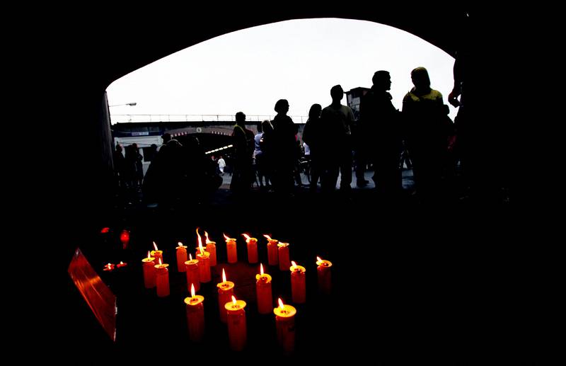 People mourn in the tunnel that formed the entrance to Love Parade grounds on July 25, 2010, where panic broke out in Duisburg, western Germany. DPA / AFP