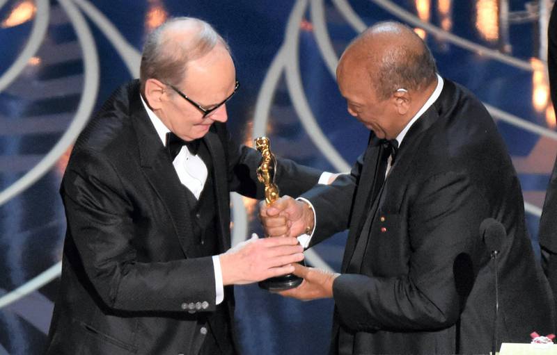 Ennio Morricone (L) accepts the award for Best Original Score, The Hateful Eight, from producer Quincy Joneson stage at the 88th Oscars on February 28, 2016 in Hollywood, California. AFP PHOTO / MARK RALSTON (Photo by MARK RALSTON / AFP)