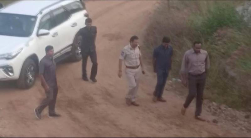 A still frame taken from a December 6, 2019 video shows various policemen and officials standing at a spot where police shot dead four men suspected of raping a veterinary doctor, in Hyderabad. ANI via Reuters