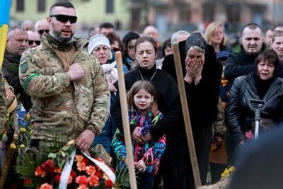Christina Dragun holds her daughter, Olya Siksoy, during the burial of her husband, Ukrainian soldier Ruslan Siksoy at Lychakiv Cemetery, Lviv. Getty