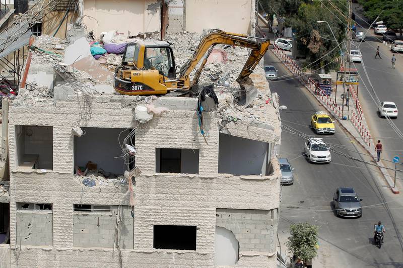 An excavator removes debris on a building damaged in Israeli air strikes in Gaza City during fighting between Israel and Hamas. Reuters