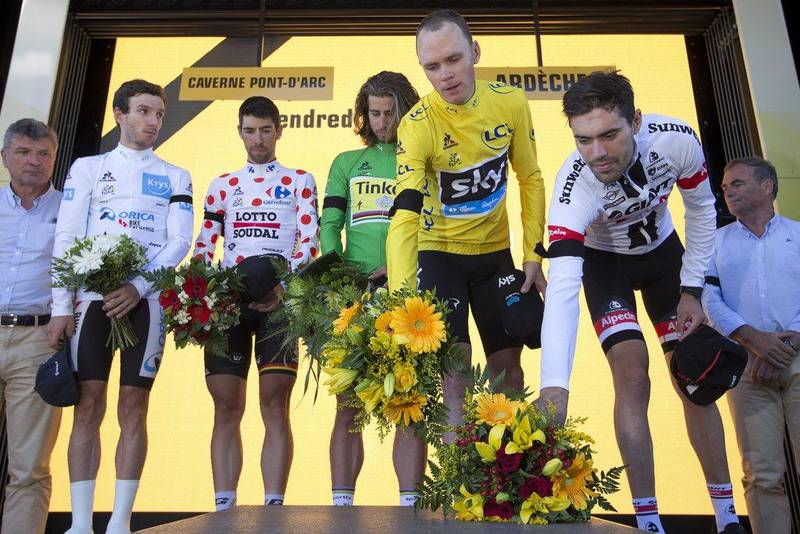 Left to right: Britain’s Adam Yates, Belgium’s Thomas de Gendt, Peter Sagan of Slovakia, Britain's Chris Froome, and stage winner Netherlands’ Tom Dumoulin lay flowers after observing a minute of silence to commemorate the victims of the Nice truck attack on the podium after Stage 13 of the Tour de France on July 15, 2016. (AP Photo/Peter Dejong)