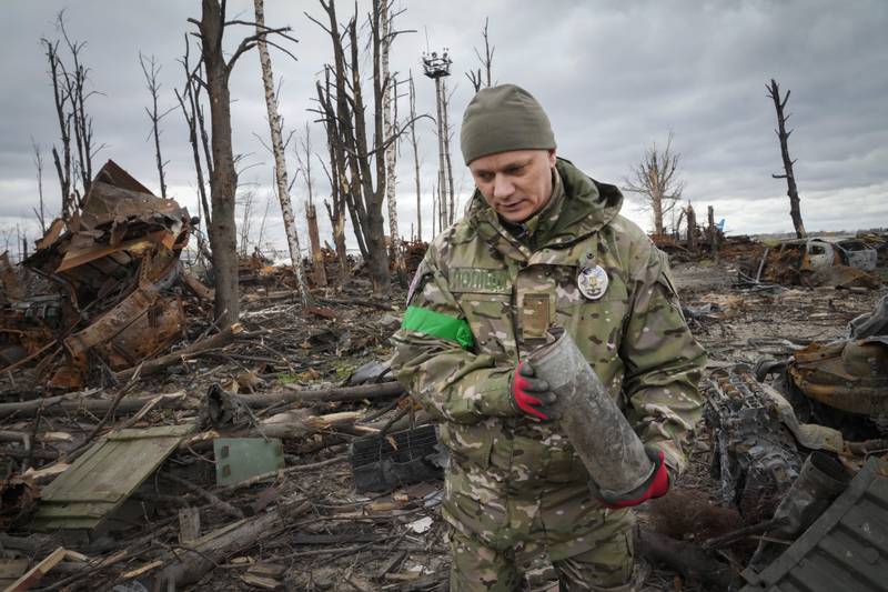 A Ukrainian Interior Ministry serviceman collects unexploded shells, grenades and mines, following fierce fighting in Hostomel. AP