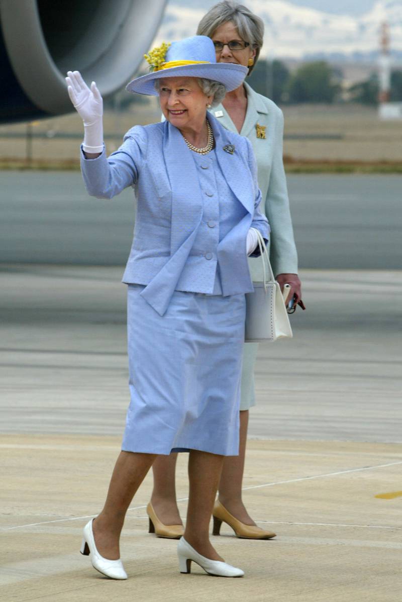 Queen Elizabeth II, wearing light blue, waves to well-wishers as she departs for Melbourne on March 15, 2006, in Canberra. Getty Images