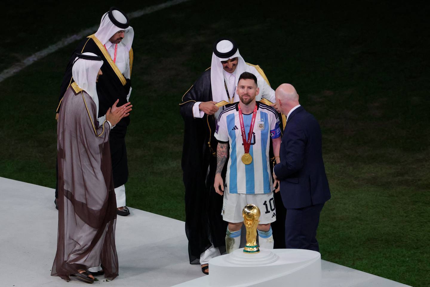 Emir of Qatar Sheikh Tamim honours Argentina's forward #10 Lionel Messi with a traditional bisht, at the end of the Qatar 2022 World Cup final football match between Argentina and France on December 18. AFP