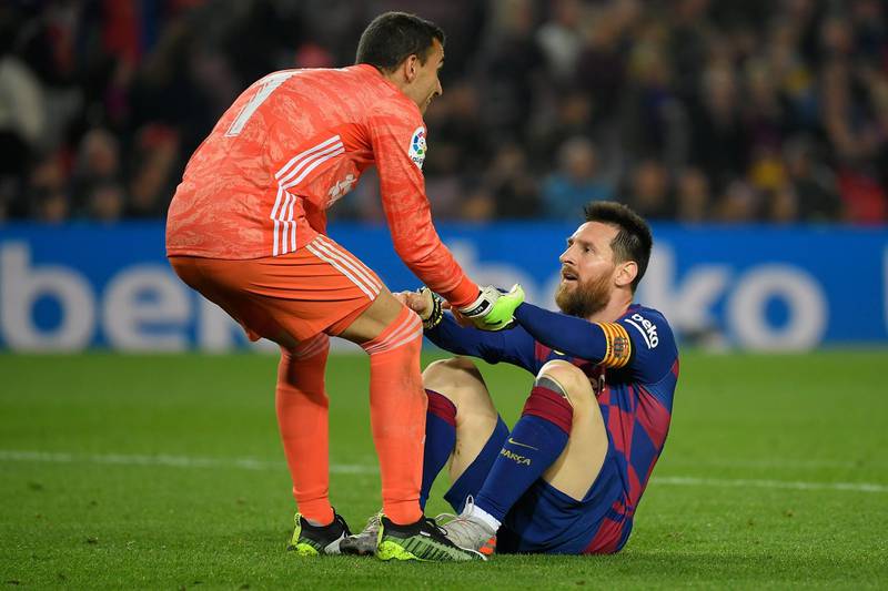 Valladolid's Spanish goalkeeper Jordi Masip helps Barcelona's Argentine forward Lionel Messi to stand up during the Spanish league football match between FC Barcelona and Real Valladolid FC at the Camp Nou stadium in Barcelona on October 29, 2019. / AFP / LLUIS GENE
