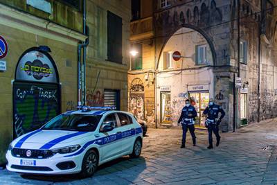 Police patrol a deserted street in the centre of Genoa, Italy. EPA