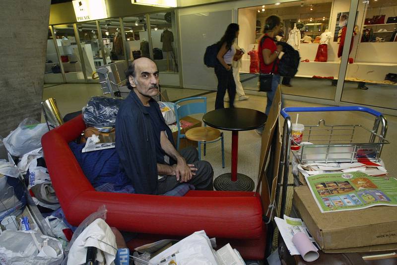 Mr Nasseri sits among his belongings in Terminal 1 of the Paris airport in 2004. AP