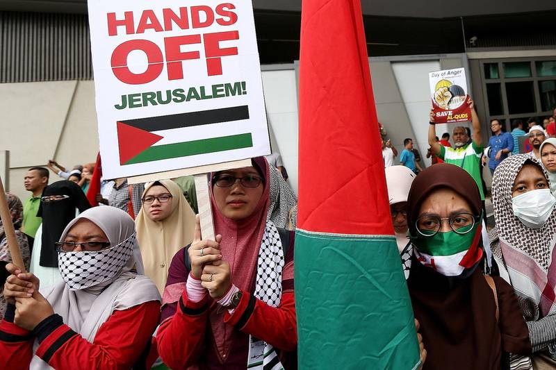 Protesters hold placards outside the US embassy in Kuala Lumpur on December 8, 2017. AFP