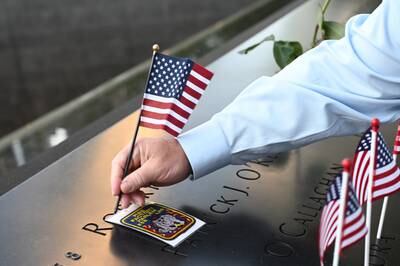 A 9. 11 Memorial staff member places a flag at the South Tower before ceremonies marking the 20th anniversary of the 9. 11 attack at the World Trade Center in New York which killed almost 3,000 people.   EPA