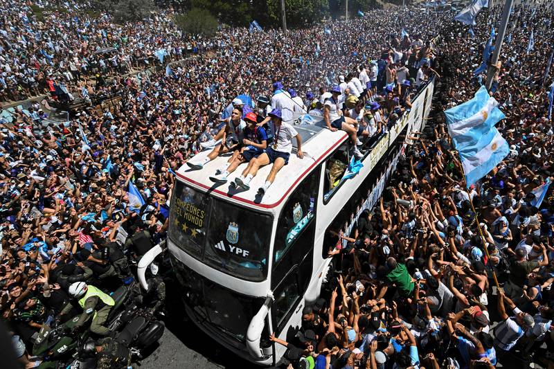 Argentina fans in Buenos Aires cheer as the team parades on a bus after winning the Qatar 2022 World Cup.   AFP