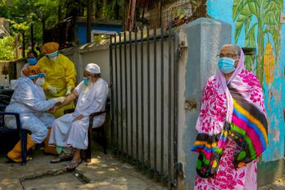 Health workers collect blood samples from a man at a locked-down area in Colombo, Sri Lanka..  EPA