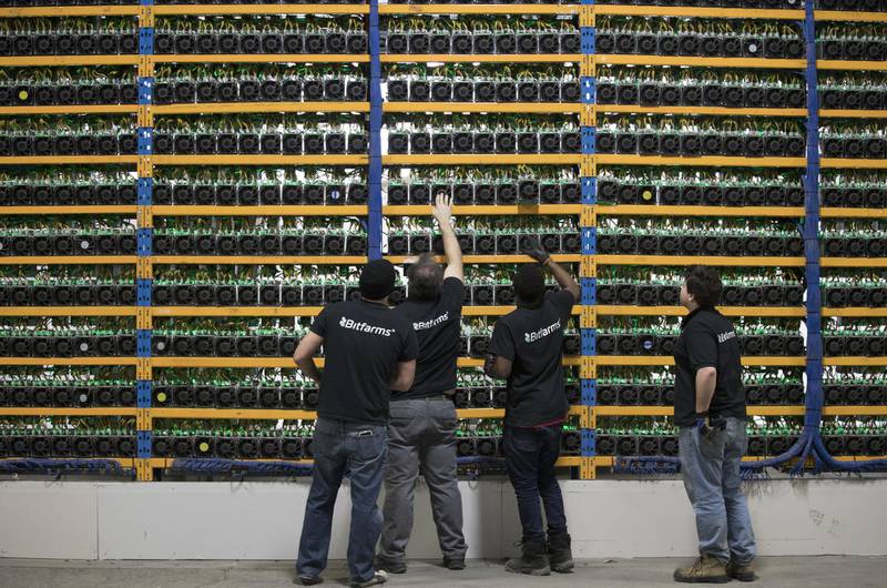 Employees check fans on mining machines at the Bitfarms cryptocurrency farming facility in Farnham, Quebec, Canada, on Wednesday, Jan. 24, 2018. Bitfarms says it's making more than $250,000 a day from minting Bitcoin, other virtual currencies and fees at four sites in the province. Photographer: Christinne Muschi/Bloomberg