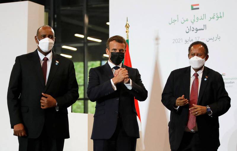 French President Emmanuel Macron, Sudan's Sovereign Council Chief General Abdel Fattah al-Burhan (L) and Sudan's Prime Minister Abdalla Hamdok react after a joint press conference during the International Conference in support of Sudan at the temporary Grand Palais in Paris. AFP