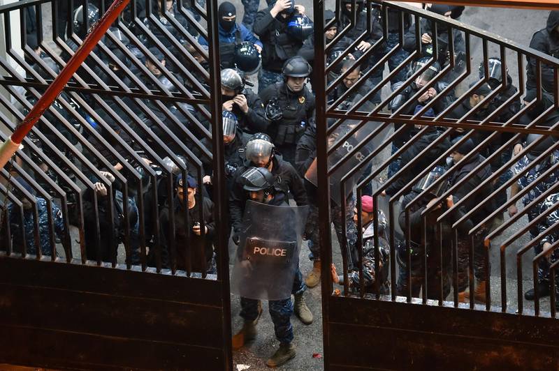 Riot police gather at the entrance of the police barracks during a protest demanding the release of 59 of their comrades who were detained following overnight clashes near Lebanese Central Bank in Beirut. EPA