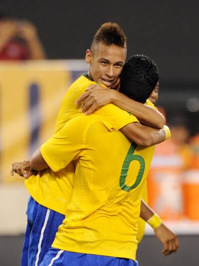 Neymar, left, is hugged by teammate Andre Santos after scoring a header on his international debut for the Selecao. AFP