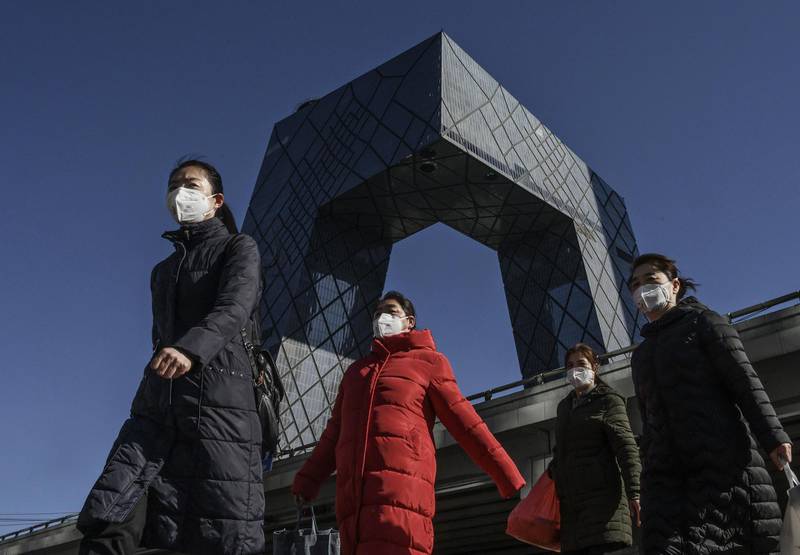 Chinese women wear  protective masks as they pass the CCTV building on their way to work on February 17, 2020 in Beijing, China. . Getty Images