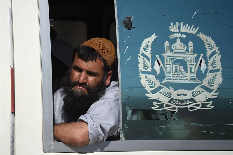 A Taliban prisoner looks out from a window of a vehicle during his release from the Bagram prison, next to the US military base in Bagram, some 50 km north of Kabul. Afghan authorities plan to release 900 more Taliban prisoners on May 26, as calls grow for the militants to extend a ceasefire on its third and final day. / AFP / WAKIL KOHSAR
