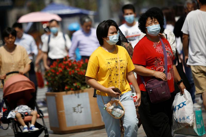 People walk at a shopping area, after Beijing Centre for Disease Prevention and Control announced that wearing face masks are no longer mandatory outdoor in Beijing. Reuters
