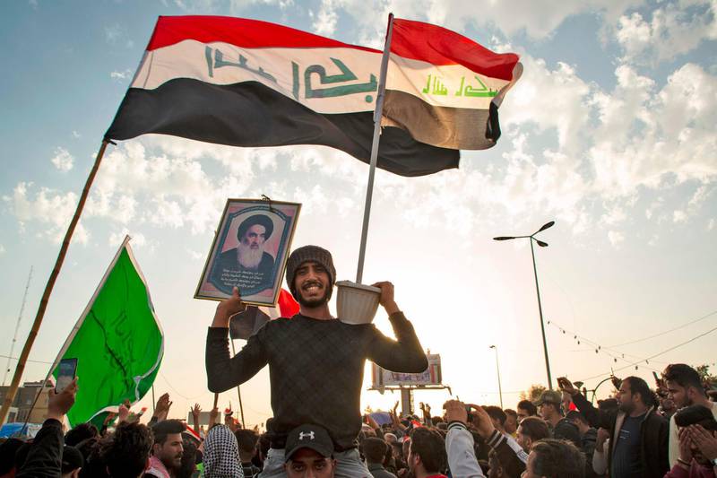 TOPSHOT - An Iraqi demonstrator carries a portrait of Grand Ayatollah Ali Sistani during an anti-government demonstration in the southern city of Basra on February 7, 2020. Iraq's top Shiite cleric condemned recent deadly attacks on anti-government demonstrators, chastising security forces for not doing more to prevent violence in protest squares across the country. Eight demonstrators were killed this week in attacks on protest camps by supporters of populist cleric Moqtada Sadr, including in the shrine city of Najaf -- home to Iraq's Shiite religious leadership.  / AFP / Hussein FALEH

