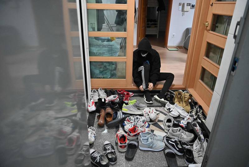 Blitzers member Choi Gyeong-seok putting on his shoes to go to a gym in the band's shared house in Seoul. AFP