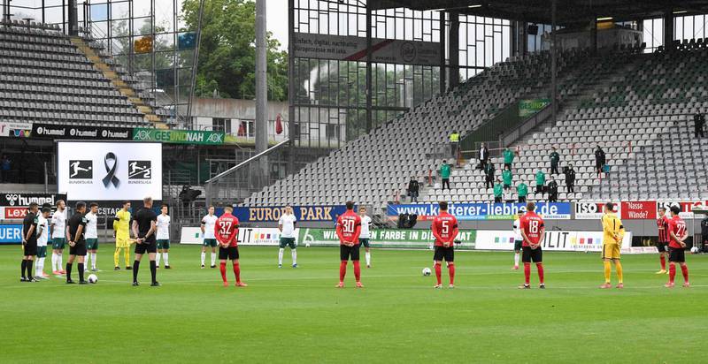 Players observe a minute of silence to commemorate the victims of the coronavirus pandemic, prior to the match between Freiburg and Werder Bremen. AP