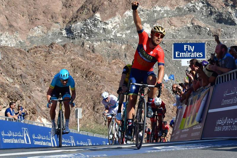 TOPSHOT - UCI World Tour team Bahrain–Merida's Italian rider Sonny Colbrelli celebrates his victory as he crosses the finish line during the fourth stage of the Dubai Tour, from Sky Dive Dubai to Hatta on February 9, 2018. / AFP PHOTO / GIUSEPPE CACACE