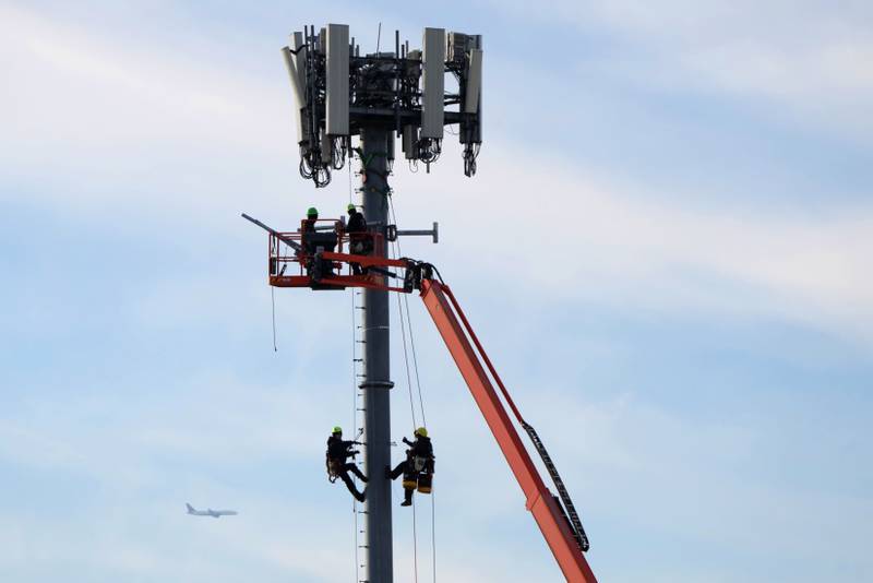 Workers install equipment on a 5G cell tower in Salt Lake City, Utah, US, on Tuesday, January 11. George Frey / Bloomberg