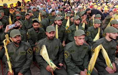 Lebanon's Hezbollah members hold party flags as they listen to their leader Sayyed Hassan Nasrallah addressing his supporters via a screen during a rally marking the anniversary of the defeat of militants near the Lebanese-Syrian border, in al-Ain village, Lebanon August 25, 2019. REUTERS/Aziz Taher
