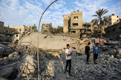 People stand in the rubble of buildings destroyed during Israeli air raids in Khan Younis, Gaza, on Friday. Getty