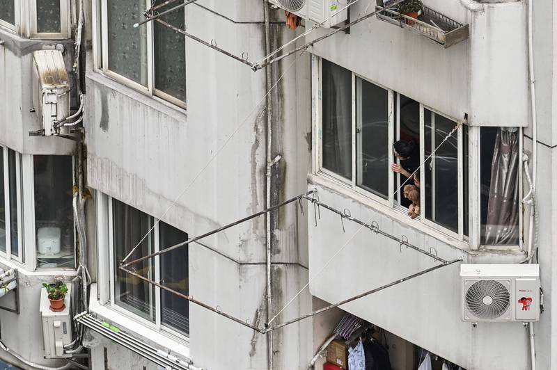 Residents in the Jingan district of Shanghai look out over their city in lockdown. AFP