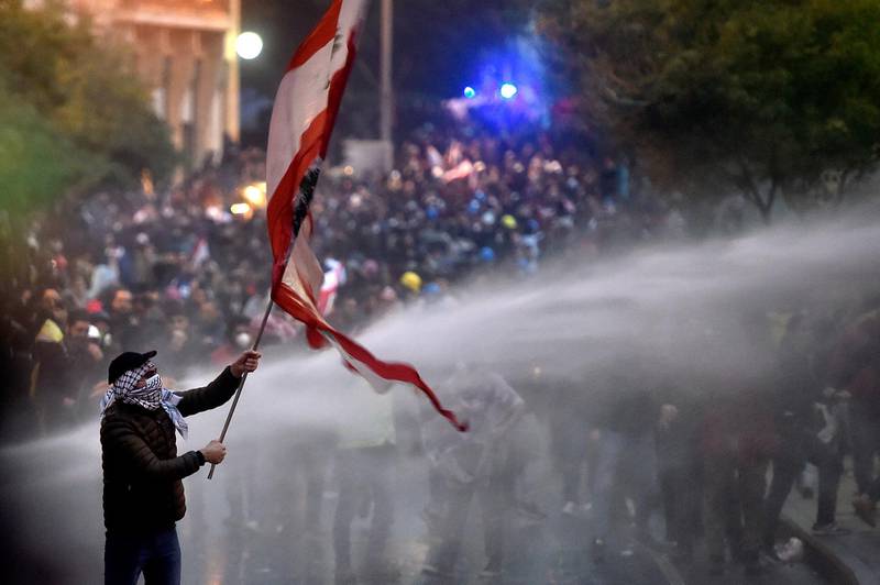 Lebanese riot police spray water cannons to disperse anti-government protesters during a protest outside of the Lebanese Parliament in downtown Beirut.  EPA