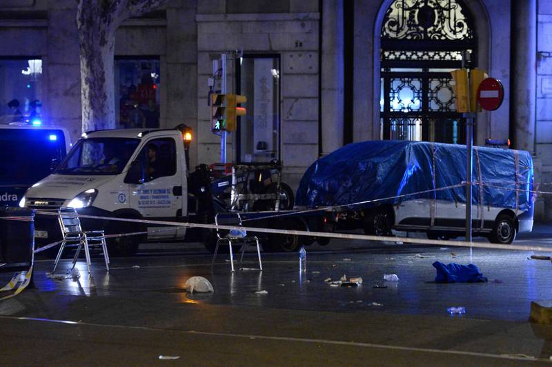 The van who ploughed into the crowd, killing at least 13 people and injuring around 100 others is towed away from the Rambla in Barcelona on August 18, 2017.
A driver deliberately rammed a van into a crowd on Barcelona's most popular street on August 17, 2017 killing at least 13 people before fleeing to a nearby bar, police said. 
Officers in Spain's second-largest city said the ramming on Las Ramblas was a "terrorist attack". The driver of a van that mowed into a packed street in Barcelona is still on the run, Spanish police said. / AFP PHOTO / Josep LAGO