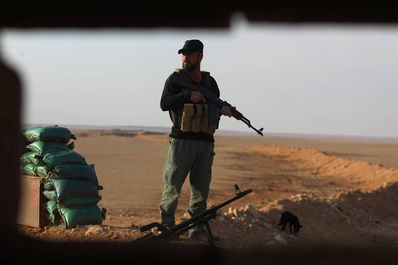 An Iraqi Shiite fighter of the Hashed al-Shaabi paramilitary force stands guard at a border position in al-Qaim in Iraq's Anbar province, opposite Albu Kamal in Syria's Deir Ezzor region on November 12, 2018.  Iraqi troops have reinforced their positions along the porous frontier with neighbouring war-torn Syria, fearing a spillover from clashes there between Islamic State group jihadists and US-backed forces. The Hashed al-Shaabi (Popular Mobilisation) auxiliary force was created by the Iraqi government in 2014, after a call to jihad by the spiritual leader of the Shiite community, Grand Ayatollah Ali Sistani to help in the fight against IS in Iraq. / AFP / AHMAD AL-RUBAYE
