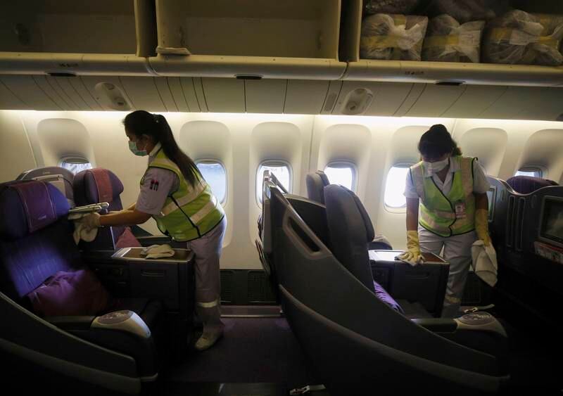 Staff cleaning business class seats on a Thai Airways aircraft. EPA