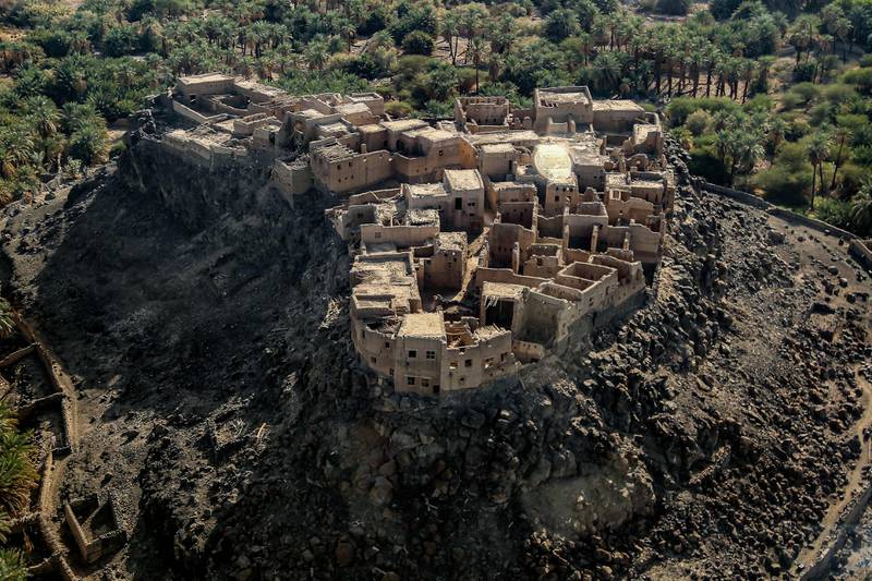 This picture taken on December 12, 2022 shows an aerial view of an old fort in the Khaybar oasis in northwestern Saudi Arabia.  - Khaybar, best known for a 7th-century fierce battle between the Islam's Prophet Mohamed and local Jewish tribes is remodelling itself as an upscale tourist draw in line with the kingdom's rebranding efforts.  Situated in an oasis amid a volcanic field north of Medina, it was once home to thousands of Jews, who were defeated in a decisive seventh-century battle with the Prophet's army as Islam expanded across the Arabian peninsula.  (Photo by Mohammad QASIM  /  AFP)