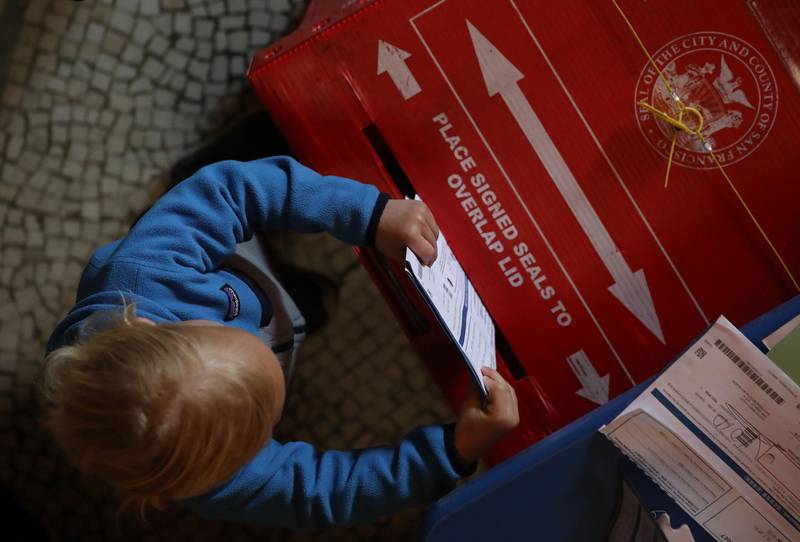 A young boy puts filled out ballots into a box in a polling station at the San Francisco Columbarium & Funeral Home in San Francisco, California. AFP