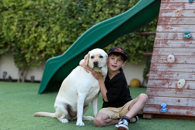 Victor Noel, 8, at home in Dubai with his dog, Sam. Khushnum Bhandari / The National