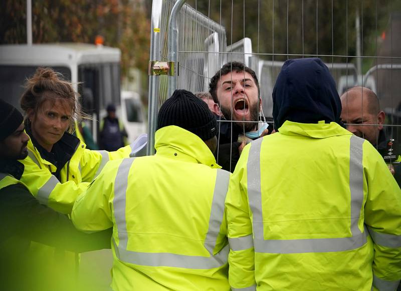 A migrant attempting to communicate with journalists is pinned at an immigration facility in Kent in November. PA Wire