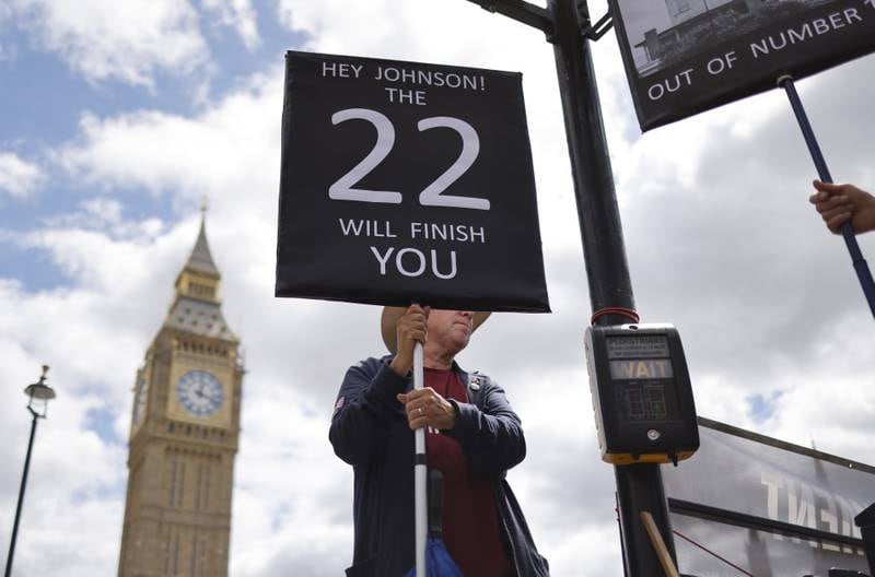 A man protests against British Prime Minister Boris Johnson outside the Houses of Parliament in London.  The 22 refers to the 1922 Committee, which has the power to push Mr Johnson out of government. EPA