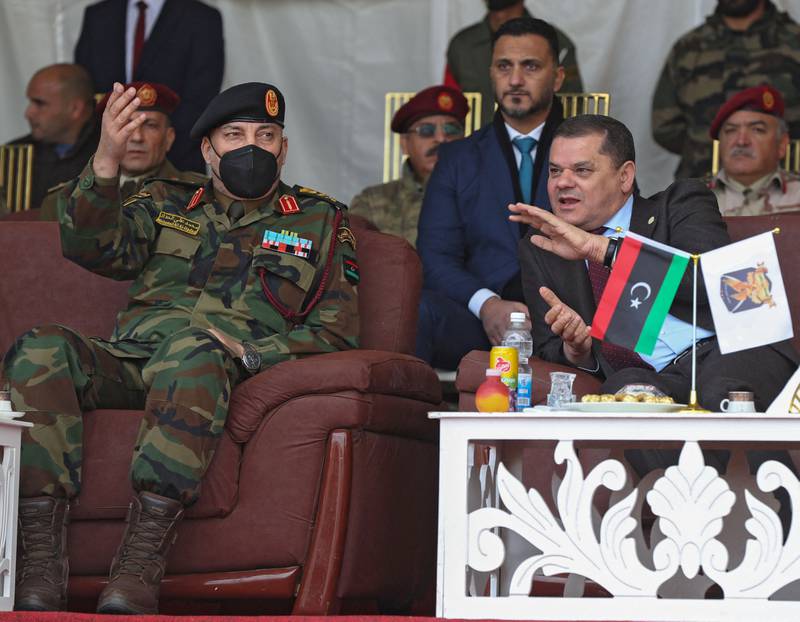 Libya’s interim prime minister, Abdul Hamid Dbeibah, sitting right, attends a military graduation ceremony in Tripoli with Lt Gen Mohammad Ali Al Haddad, chief of the general staff of the Libyan army, on January 23, 2022. AFP