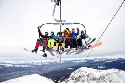 Skiers and snowboarders gesture from a chairlift as La Masella ski resort re-opensi n Masella, Spain. Reuters