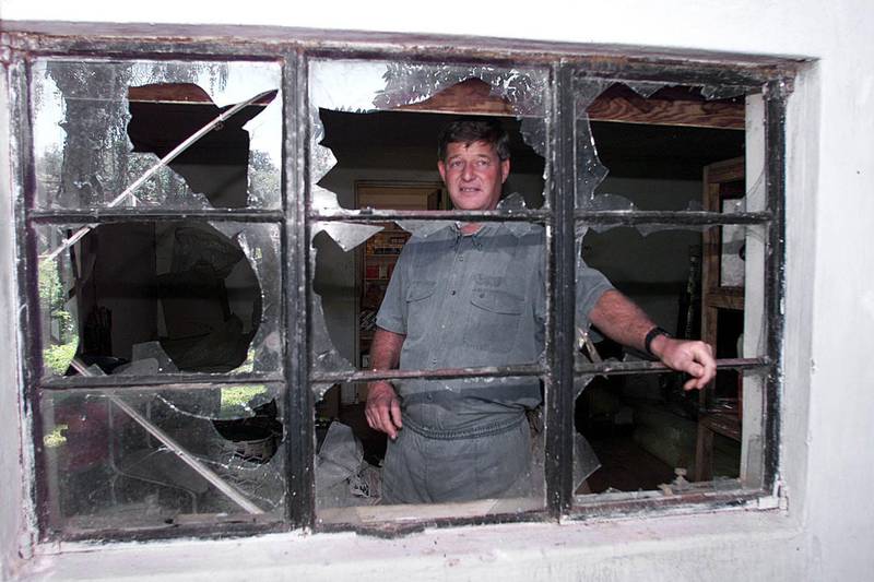 Zimbabwean farmer Paul Retzlaff stands 12 April 2000 in front of a broken window at his home in Arcturus, Gormonzi district, 30 kms east of Harare, a day after clashes broke out at his farm when drunken would-be squatters invaded the property before being repelled by black farm workers. Retzlaff said shots had been fired by the invaders, including a leading veteran of the war against white rule in the 1970s. The couple was saved after black farm workers from neighboring farms responded to a call for help over ham radio. His wife Liz said the invaders, who appeared drunk, were shouting that they had President Robert Mugabe's permission to invade the property.   / AFP PHOTO / ALEXANDER JOE