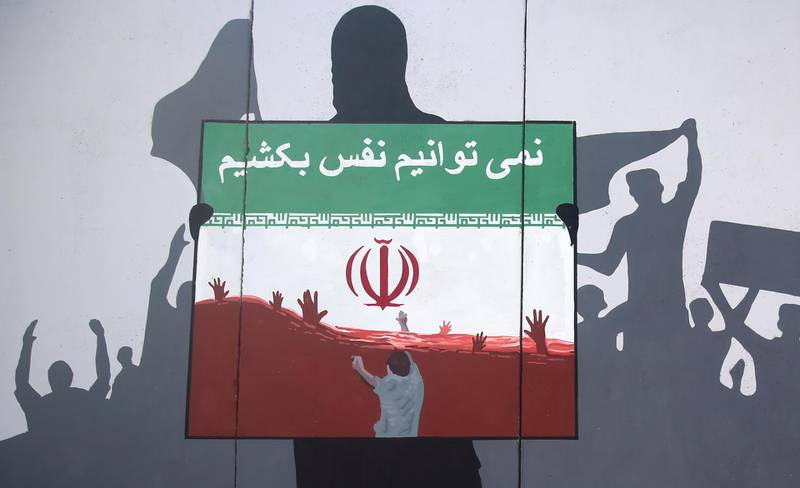 A view of a painting on a wall written in the Dari Language reading "We cannot breath" during a protest denouncing the killings of Afghan refugees in Iran in Kabul, Afghanistan, Monday, June 15, 2020. The violent deaths of Afghan refugees inside Iran has sparked an uproar despite denials from Tehran. (AP Photo/ Rahmat Gul)