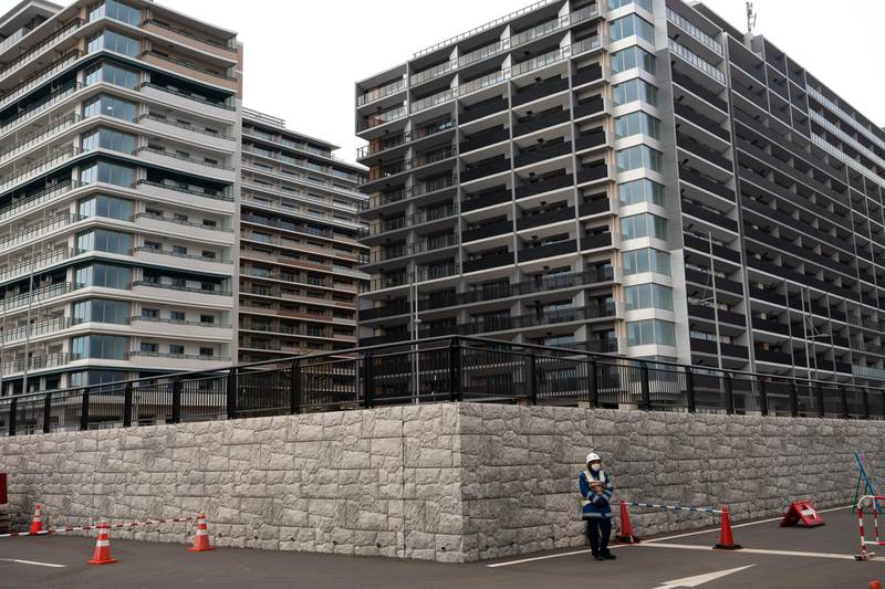 A guard stands in front of apartment buildings at the athletes' village for the Tokyo 2020 Olympics in Tokyo on  Monday. AP