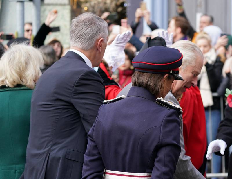 A protester, top left, throws eggs towards King Charles and the Queen Consort Camilla as they arrive. PA