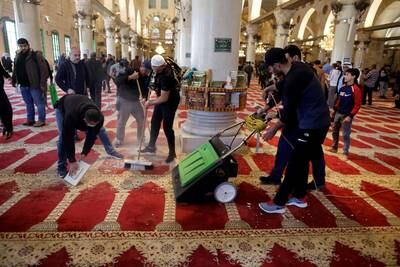 Palestinians clean Jerusalem's Al Aqsa Mosque after Israeli security forces entered. Reuters